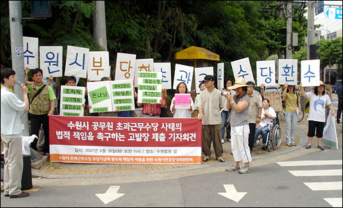 시민공대위 관계자들이 수원지검 앞 도로 횡단보도 옆에서 수원시장을 비롯한 수원시 간부 공무원들을 검찰에 고발하게 된 배경을 설명하는 기자회견을 열고 있다. 